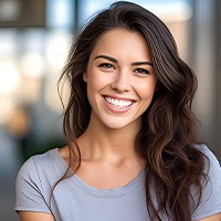 Closeup of woman in grey shirt smiling outside