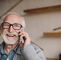 Man in black-framed glasses talking on smartphone