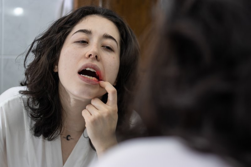 Patient checking their gums in the mirror for gingivitis